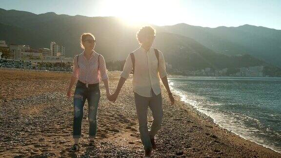 夏日里一对年轻夫妇沿着海边散步