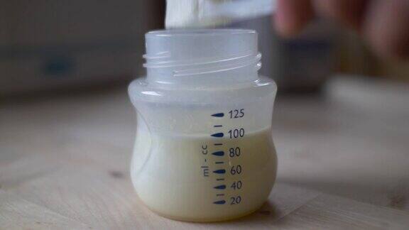 母亲准备婴儿配方奶粉的特写