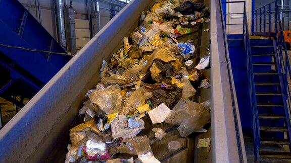 垃圾、垃圾、垃圾堆放在回收厂的分类传送带上