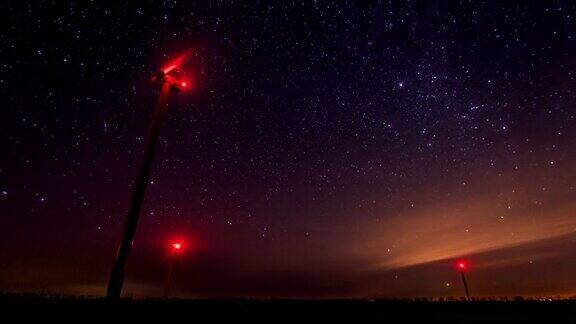 风力涡轮机在夜间发电以旋转的星空为背景