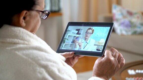 医学在线老年妇女咨询她的医生使用视频聊天在家