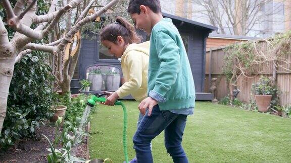 孩子们在花园里一起笑着浇水