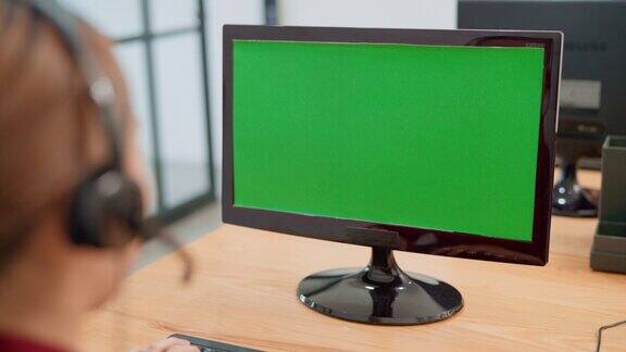 亚洲呼叫中心看着绿色屏幕的电脑