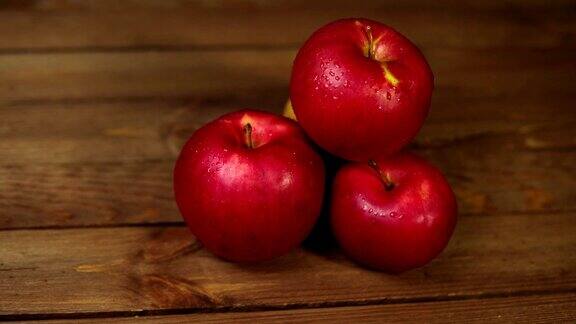 深色木桌上放着一堆诱人的红苹果