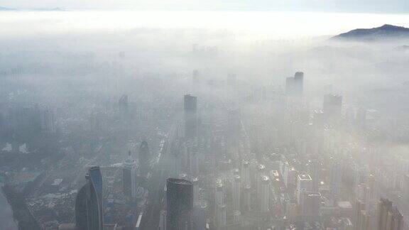 日出时城市建筑被浓雾笼罩