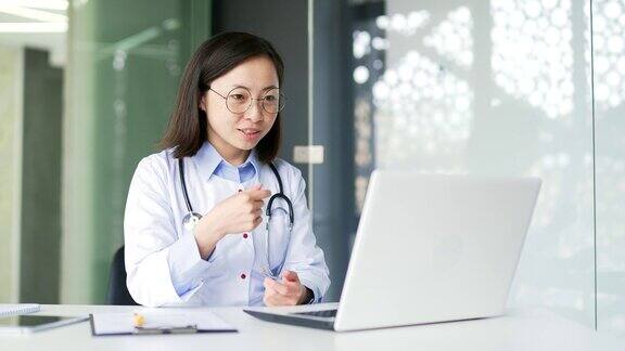 亚洲女医生在医院诊所用笔记本电脑进行视频通话
