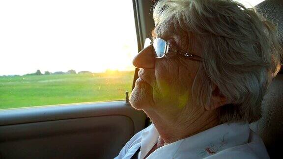 夕阳西下时坐在车里的老年妇女微笑着