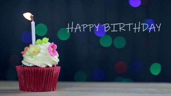 杯子蛋糕和生日快乐的文字在屏幕背景生日蛋糕和一支蓝色的蜡烛