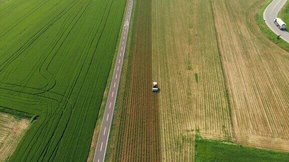 空中:拖拉机在耕地上工作骑自行车穿越乡村