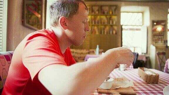 坐在咖啡馆里吃玉米饼的男人镜头在移动