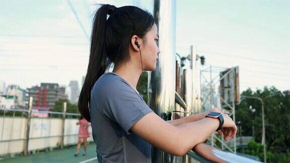 年轻的亚洲运动员跑步后休息日落时分在街上慢跑锻炼的生活方式健康的生活方式