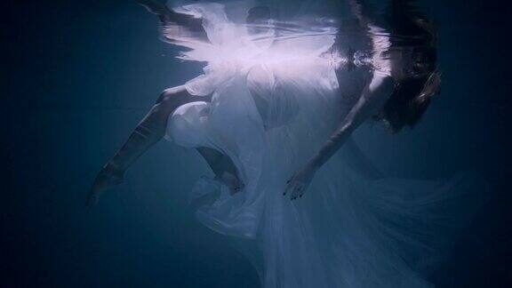 水下的年轻女子她穿着一件白色的连衣裙