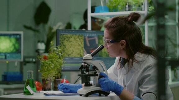 制药科学家在显微镜下观察绿叶样本
