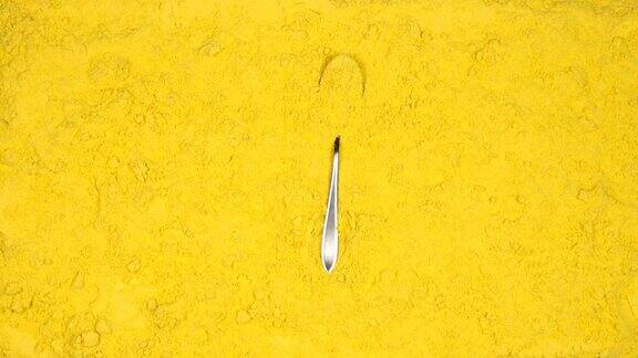 俯视图:勺子与姜黄粉落在姜黄粉-慢镜头