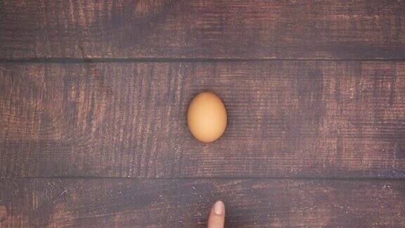 煮鸡蛋在木制的背景和剥一个鸡蛋-停止运动