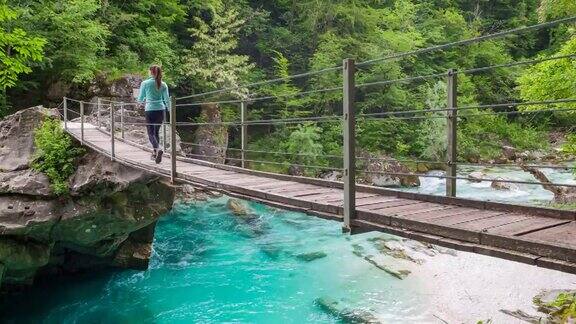 女游客徒步穿越山涧峡谷上的木桥