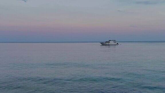 日落时在海上航行的小船的近景