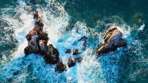 巨大的海浪冲击着岩石般的海边悬崖溅起白色的泡沫