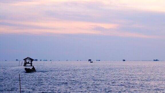 清晨金色阳光下海上渔船的剪影
