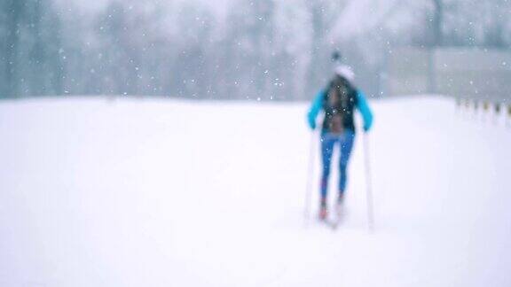 雪景中一名女子滑雪运动员的后视图
