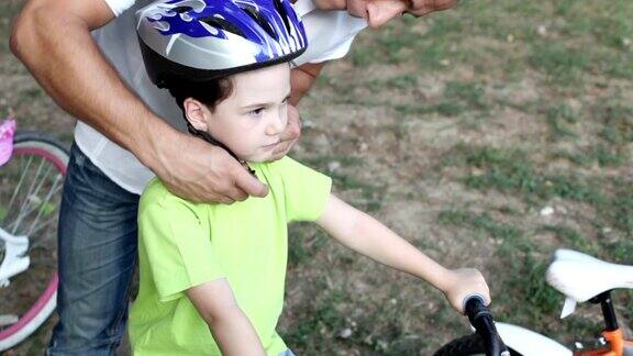 父亲帮助孩子戴自行车头盔