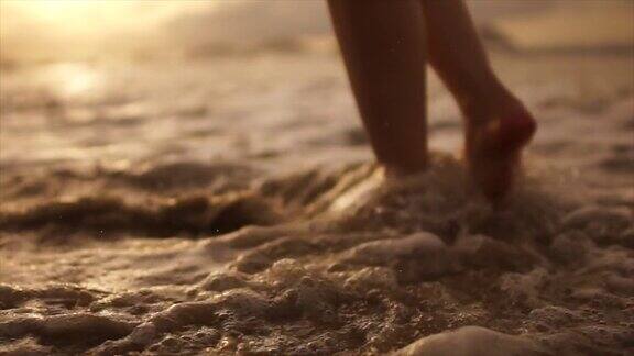 日落时寂寞的女人走在海边