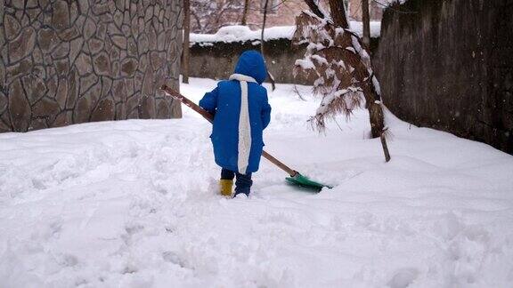 小男孩在冬天铲雪