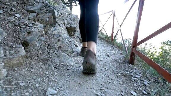 在石山步道上徒步旅行的女旅行者的脚上的视图慢动作