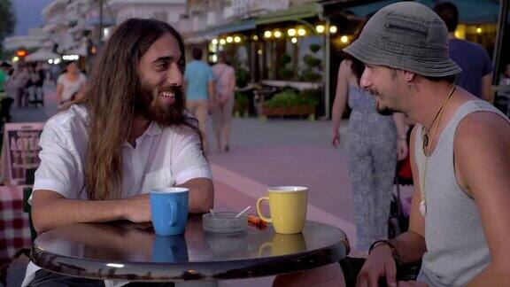 两个男人在街头咖啡馆聊天喝酒