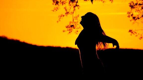 慢镜头:年轻女子在夕阳下旋转