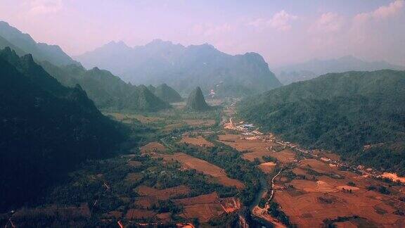 美丽的日出在野生森林山脉和河谷在老挝的早晨风景航空视频飞越山脉