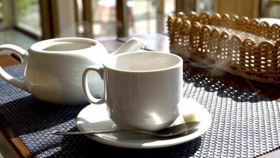 在咖啡馆的桌子上冒着热气的白色茶杯一杯茶一杯咖啡热的饮料
