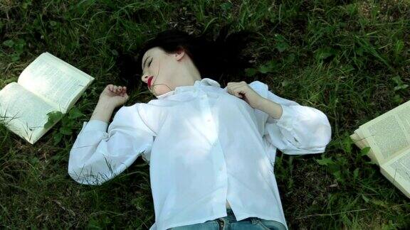 读书累了这个女孩正在草地上睡觉放大
