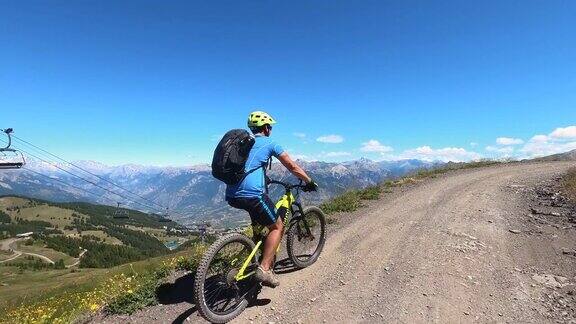 在夏日阳光明媚的日子里一名年轻人在山顶上骑着电动山地车