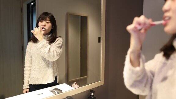 年轻女子在酒店房间刷牙