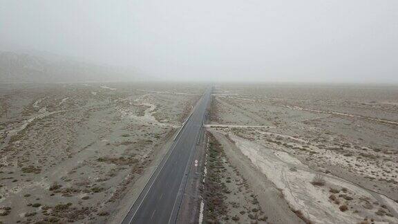 新疆戈壁沙漠上的一条公路位于天山和塔克拉玛干沙漠之间