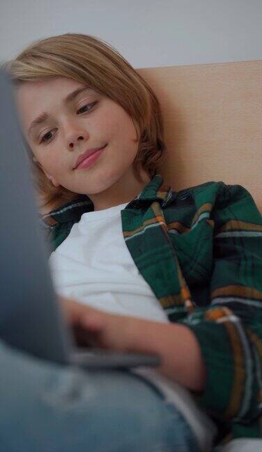 聪明的白人中学男孩使用笔记本电脑孩子在键盘上打字玩电子游戏在线导师数字课堂在家电脑上进行网络教学虚拟教育电子教育垂直