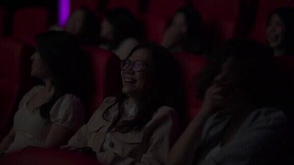 亚洲华人成熟女性和她的朋友们在电影院笑着看电影