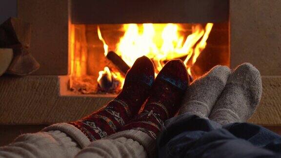 热恋中的情侣穿着针织羊毛袜子躺在壁炉旁