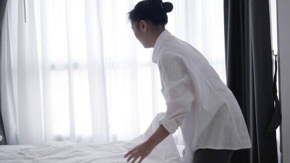 特写亚洲女人扔白色毯子在床上-股票视频
