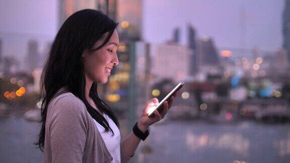 女商人晚上在城市里使用智能手机