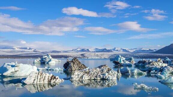 4k时间流逝云移动与蓝色冰山漂浮在冰岛Jokulsarlon冰川泻湖