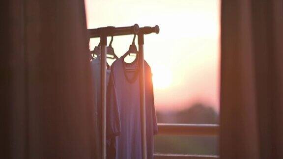 日落透过窗户望着城市阳台上挂着湿布晾衣绳晒衣夹