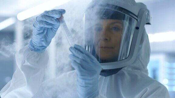 医学病毒学研究科学家穿着防护服戴着面罩她正在检查从冰箱里取出的病毒串的试管她在一个无菌的高科技实验室研究机构工作