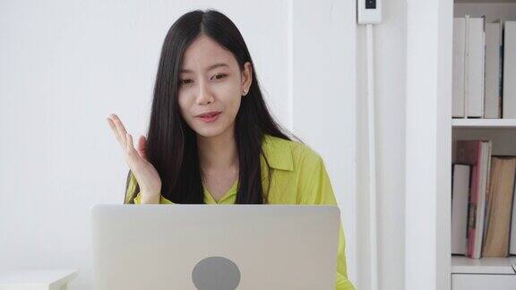 年轻的亚洲商务女性使用笔记本电脑进行在线视频会议与社交距离商务女性使用视频电话工作新的常态沟通和在家工作