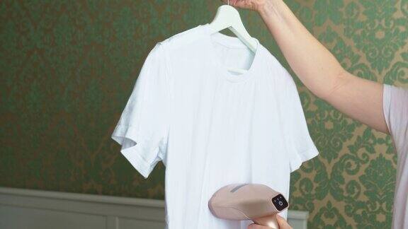 妇女用手提蒸笼熨烫白色t恤