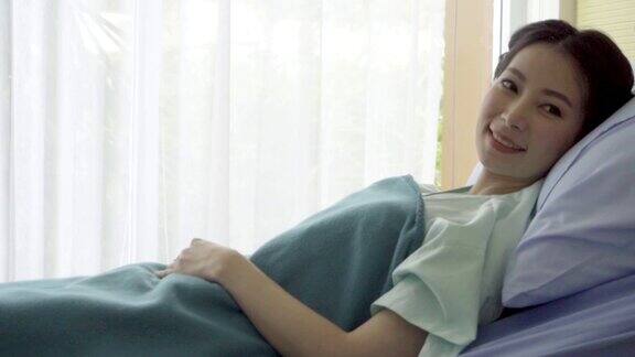 快乐的病人在病房的床上休息医疗保健理念
