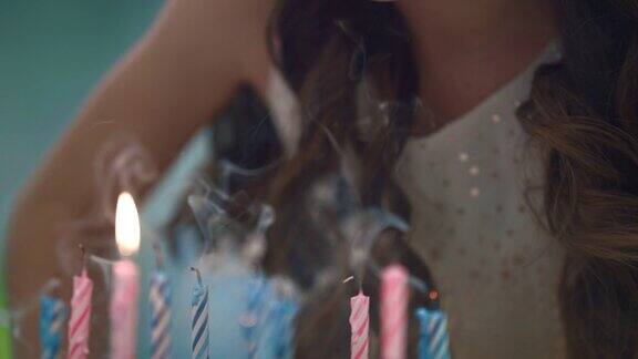 女孩在派对蛋糕上吹蜡烛儿童生日庆祝传统
