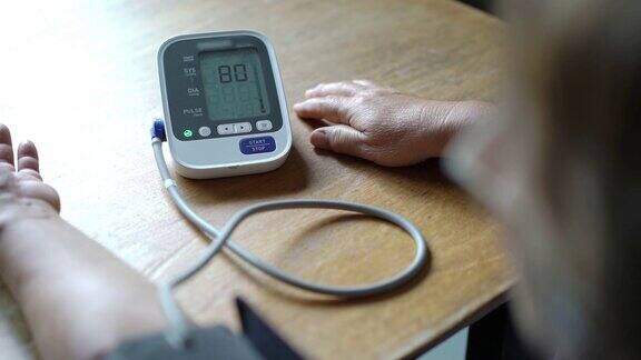 特写亚洲妇女测量血压在家