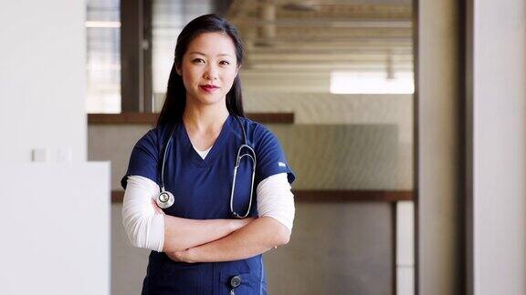 年轻的亚洲女医生穿着手术服